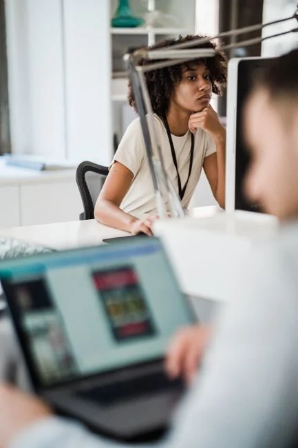 Un espace de travail moderne où des mains analysent des données marketing sur un ordinateur portable et des documents papier.